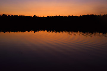 Sunset over forest lake
