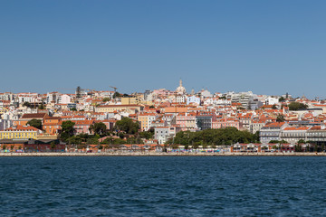 Fototapeta na wymiar City of Lisbon, Portugal, viewed from the Tagus River on a sunny day. Copy space.
