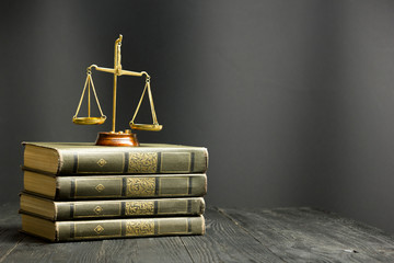 Law concept - Open law book with a wooden judges gavel on table in a courtroom or law enforcement...