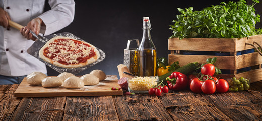 Chef in a pizzeria preparing an Italian pizza
