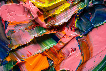 Artistic background. Different bright colors of oil paints are mixed on a palette close-up.