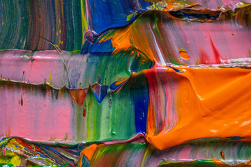 Artistic background. Different bright colors of oil paints are mixed on a palette close-up.
