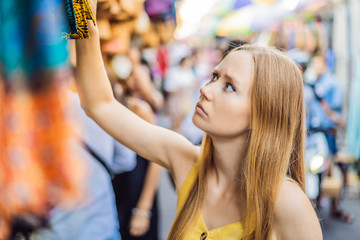 Woman traveler choose souvenirs in the market at Ubud in Bali, Indonesia