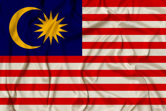beautiful photo of the national flag of Malaysia on delicate shiny silk with soft draperies, the concept of state power, country life, horizontal, close-up, copy space