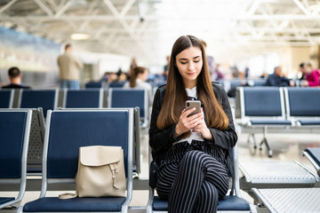 Young woman using mobile phone at airport