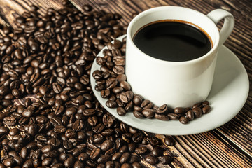 a cup of coffee with coffee beans on the rusty wooden table