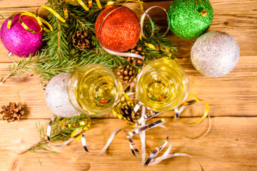 Two wineglasses with champagne and different christmas decorations on wooden table. Top view
