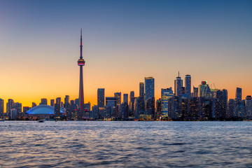 Fototapeta premium Skyline of Toronto at sunset with CN Tower over Ontario Lake, Canada