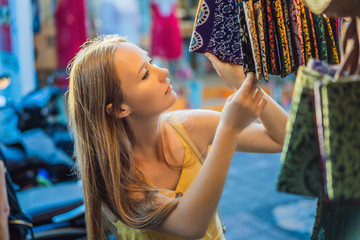 Woman traveler choose souvenirs in the market at Ubud in Bali, Indonesia