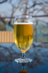 A Glass of Chilled Beer Outdoors on a Table 