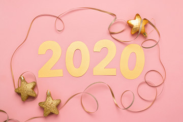 Obraz premium The symbol of the new year, numbers 2020 cut out of gold paper on pink paper background. New Year or Christmas concept.