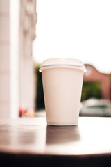 Paper cup on a wooden table. Coffee to go.