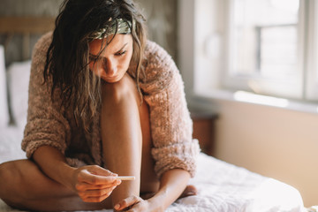 Worried woman looking at pregnancy test 