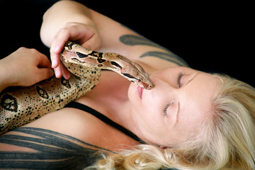 Portrait of girl with Boa constrictor snake. Beautiful woman holds snake in hands and posing in...