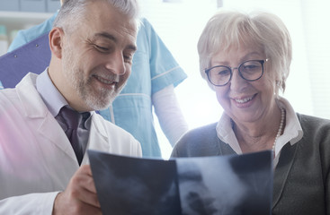 Radiologist checking an x-ray image with a senior patient
