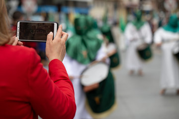 Woman taking a photo of the procession, Holy Week
