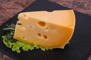 Maasdam cheese  in the board served salad leaves