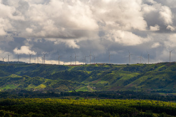 Fototapeta na wymiar Wind turbines on top mountain with cloudy background.