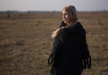 teen girl with blond hair in a hood in the desert