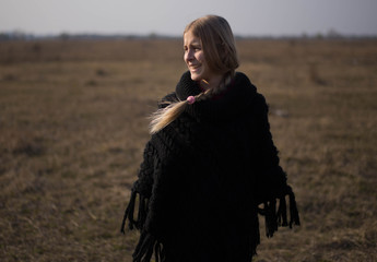 teen girl with blond hair in a hood in the desert