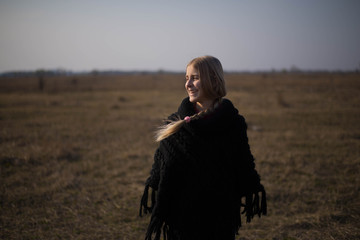 teen girl with blond hair in a hood in the desert