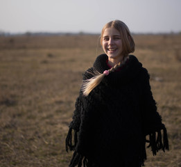 teen girl with blond hair in a hood in the desert