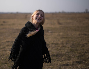 teen girl with blond hair in a hood in the desert