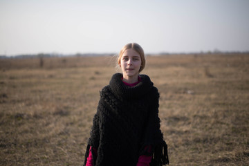 teen girl with blond hair in a hood in the desert