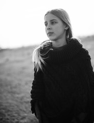 teen girl with blond hair in a hood in the desert