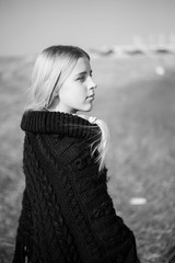 teen girl with blond hair in a hood in the desert