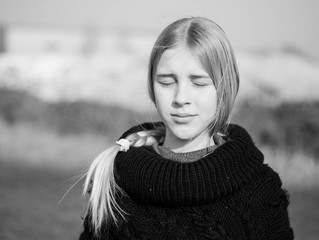 teen girl with blond hair in a hood in the desert