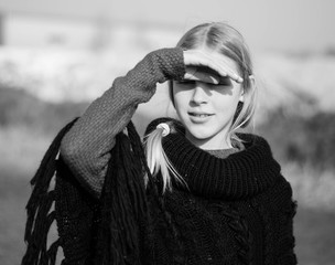 teen girl with blond hair in a hood in the desert