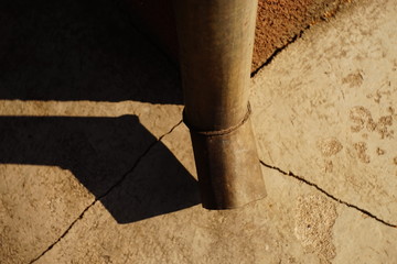 Downpipe at the corner of the building, cracks in the blind area of the house, sunlight and shadow...