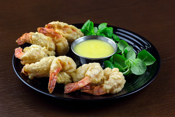 shrimp in batter with sauce and salad in a plate