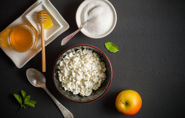 Fresh white cottage cheese in a bowl on the table. Tasty and healthy breakfast. dark stone surface. View from above. A lot of space for text.