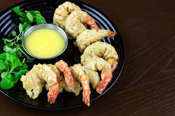 shrimp in batter with sauce and salad in a plate