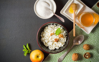 Fresh white cottage cheese in a bowl on the table. Tasty and healthy breakfast. dark stone surface. View from above. A lot of space for text.