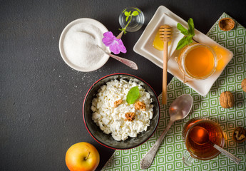 Fresh white cottage cheese in a bowl on the table. Tasty and healthy breakfast. dark stone surface. View from above. A lot of space for text.