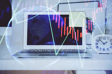Stock market graph on background with desk and personal computer. Multi exposure. Concept of financial analysis.