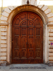 Fototapeta na wymiar old wooden door on the wall of an italian house