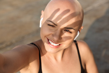 Image closeup of cheerful bald using earphones while working out