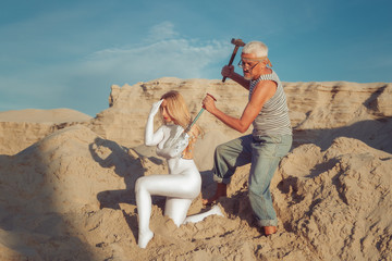 An old man revives a stone female statue. Marble woman comes to life. A man creates a woman.