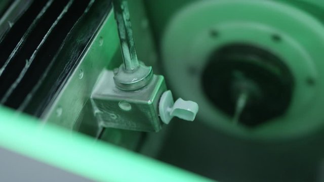 Close up of dental professional removing crown from in office milling unit
