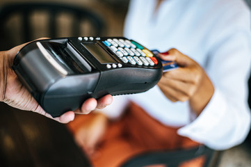 Close-up image of woman paying with credit card in cafe