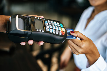 Close-up image of woman paying with credit card in cafe