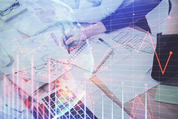 A woman hands writing information about stock market in notepad. Forex chart holograms in front. Concept of research. Double exposure