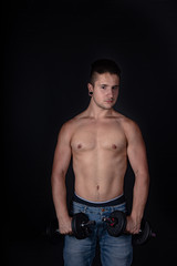 Fototapeta premium Chico fitness gimnasio training pesas fondo negro