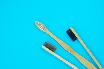 Wooden bamboo toothbrushes isolated on blue background. Concept dental eco-friendly...