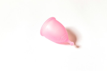 Pink menstrual cup on white background. Flat lay, top view. copy space. Concept female intimate hygiene period products and zero waste.