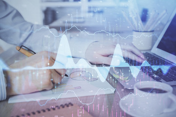 Multi exposure of stock market graph with man working on laptop on background. Concept of financial analysis.
